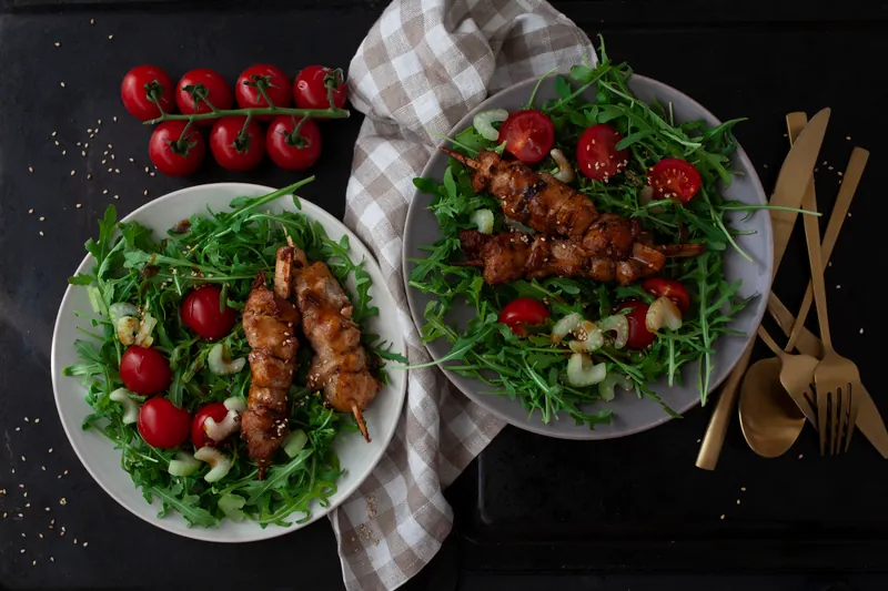 Marinede svinemørbrad på spyd på bund af frisk salat og broccoli - Ketoliv